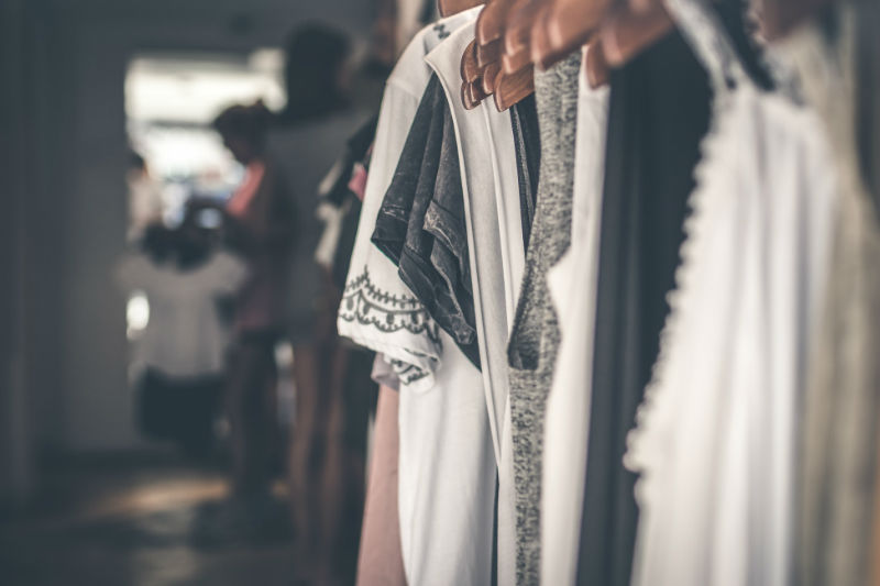 clothes on wooden hangers in a store